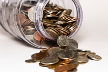 coins spilling out of a jar onto a white table