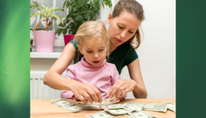 mother daughter at kitchen table with. money