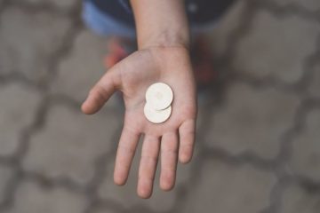 kids hand with 2 coins