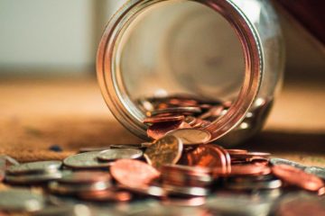 jar on table with coins spilling out